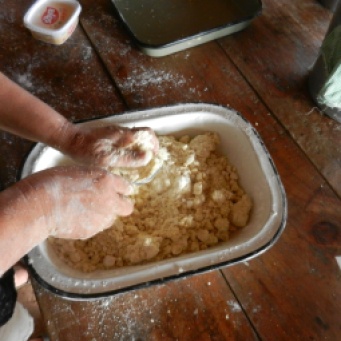 Mixing mbeju dough by hand. It requires a lot of squeezing to distribute the moisture throughout the fairly dry dough.